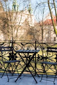 una mesa y sillas sentadas frente a una valla en Pokoje Bagatela Stare Miasto, en Cracovia