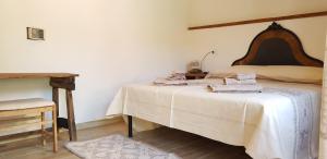 a bedroom with two beds in a room with a table at S'Ommu Ezza in Narbolia