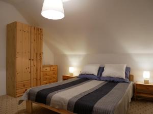 a bedroom with a bed and a dresser and two lamps at Herőke Vendégház in Terény