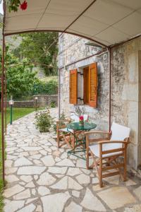 patio ze stołem, krzesłami i parasolem w obiekcie Villa Kastania w mieście Kastanéa