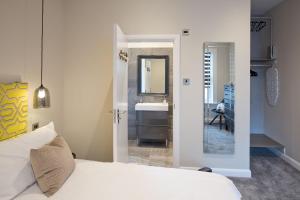 a bedroom with a bed and a bathroom with a sink at Blackbird Luxury Apartments Room 2 in Blackpool