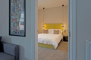 a bedroom with a white bed with a yellow headboard at Blackbird Luxury Apartments Room 2 in Blackpool