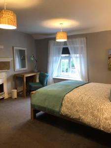 1 dormitorio con cama, escritorio y ventana en Blue Sky Cottage en Matlock