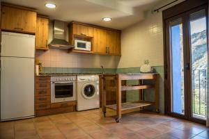 a kitchen with a washer and dryer in it at CASA BERNAT in Aren