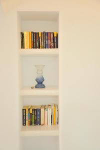 a book shelf with books and a vase on it at Veletas Apartments in Adamantas