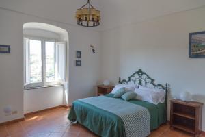 a bedroom with a bed with a green blanket at Villa il Turro in Massa Lubrense