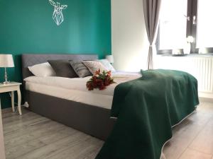 a bedroom with a bed with a green wall at apartament Joanny Bator in Jelenia Góra