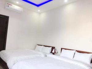 two beds in a room with white walls at Motel Thanh Long in Danang +2 photos
