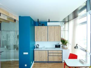a kitchen with blue and wooden cabinets and a table at Panoramic View in Odesa