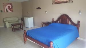 1 dormitorio con 1 cama, 1 silla y nevera en Hotel Confort, en Santiago del Estero 10 fotos más