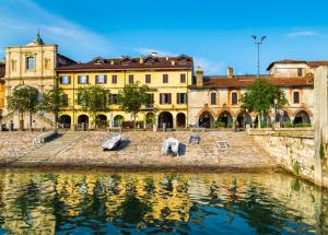 アローナにあるAppartamento Lago Maggioreの水の隣の建物