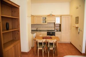 a small kitchen with a wooden table and chairs at Casa del Grillo in Molfetta +18 photos