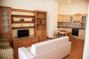 a living room with a white couch and a kitchen at Casa del Grillo in Molfetta