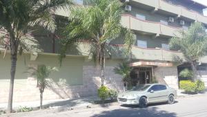Un coche blanco aparcado delante de un edificio en Hotel Confort, en Santiago del Estero