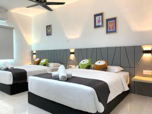 a bedroom with two beds and a ceiling fan at Langkawi Cozy Holiday Home at Bukit Indah by Zervin in Kuah