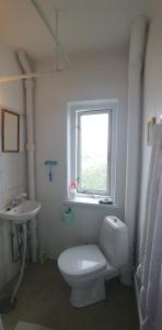 a white bathroom with a toilet and a sink at My Bureau Apartment in Korsør