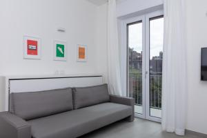 salon z kanapą przed oknem w obiekcie Cirene Apartments Milano w Mediolanie