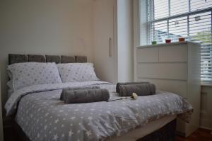 a bedroom with a bed with two pillows on it at Apartment 4 Hamilton Square in Birkenhead