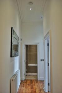 um corredor com uma porta que leva a uma casa de banho em Apartment 4 Hamilton Square em Birkenhead