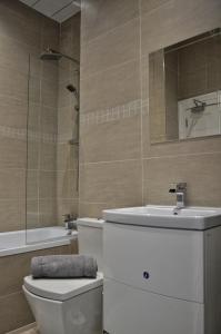 uma casa de banho com um WC, um lavatório e um espelho. em Apartment 4 Hamilton Square em Birkenhead