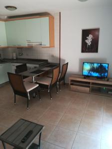 salon ze stołem, krzesłami i telewizorem w obiekcie buddya w mieście Costa Del Silencio