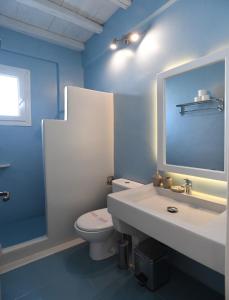 a blue bathroom with a toilet and a sink at Nostos Beachfront Apartments & Studios in Agios Ioannis +37 photos