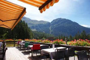 a patio with tables and chairs and a view of mountains at Kessler's Kulm Gästehaus in Davos