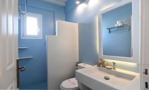 a blue bathroom with a sink and a toilet at Nostos Beachfront Apartments & Studios in Agios Ioannis