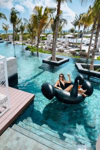 una mujer montada en un tubo interior en el agua en un resort en TRS Coral Hotel - Adults Only - All Inclusive, en Cancún