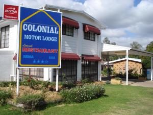 a white building with a sign on the side of it at Colonial Motor Lodge Scone in Scone