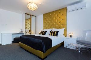 a bedroom with a large bed with a large headboard at B Gold Luxury rooms B&B in Split