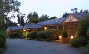 a large house with a driveway in front of it at Melaleuca Lodge Beaconsfield in Beaconsfield