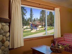a living room with a window with a view of a playground at Patricia Lake Bungalows in Jasper