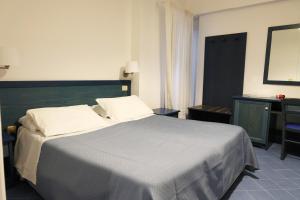 a bedroom with a large bed and a mirror at Hotel Baia Di Puolo in Massa Lubrense