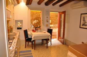 uma cozinha e sala de jantar com mesa e cadeiras em Henry's Heaven Apartment em Veneza