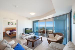 a living room filled with furniture and a tv at Blue C Coolangatta in Gold Coast