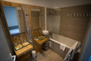 an overhead view of a bathroom with two sinks and a tub at Le Relais Du Lac in Hossegor