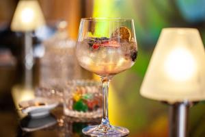 a glass of wine sitting on a table next to a lamp at Grupotel Parc Natural & Spa in Playa de Muro