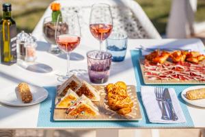 a table with two plates of food and glasses of wine at Grupotel Parc Natural & Spa in Playa de Muro