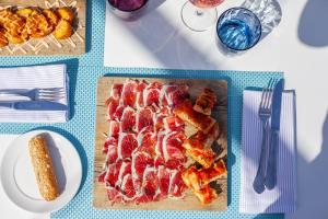 a table with bacon and corn and plates of food at Grupotel Parc Natural & Spa in Playa de Muro