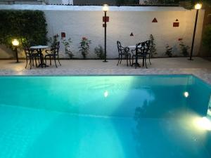a swimming pool with chairs and a table in a patio at Hotel Bakos in Loutraki