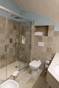 a bathroom with a toilet and a glass shower at Hotel Baia Di Puolo in Massa Lubrense