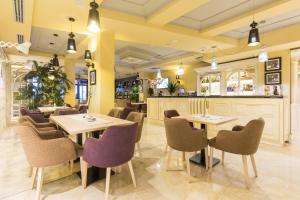 um restaurante com mesas e cadeiras e um bar em Xenon Hotel & SPA em Belgrado