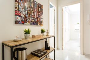 una sala de estar con una mesa y una pintura en la pared en Apartamento semi-industrial palacio Castilla, en Jerez de la Frontera