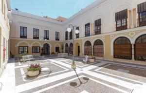 un gran edificio con un patio con bancos y mesas en Apartamento semi-industrial palacio Castilla, en Jerez de la Frontera