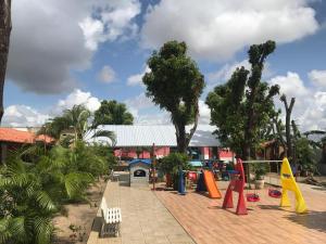 a resort with a playground with colorful equipment and trees at Hotel Cabana in Teresina