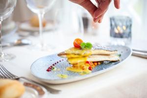 a person is sprinkling sauce on a plate of food at Grupotel Parc Natural & Spa in Playa de Muro