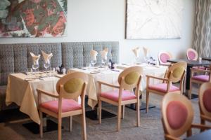 a dining room with tables and pink chairs at Grupotel Parc Natural & Spa in Playa de Muro