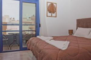 a bedroom with a bed with two white towels on it at Danaos Hotel in Chania