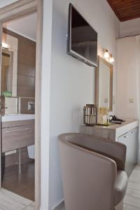 a bathroom with a sink, toilet, and bathtub at Danaos Hotel in Chania